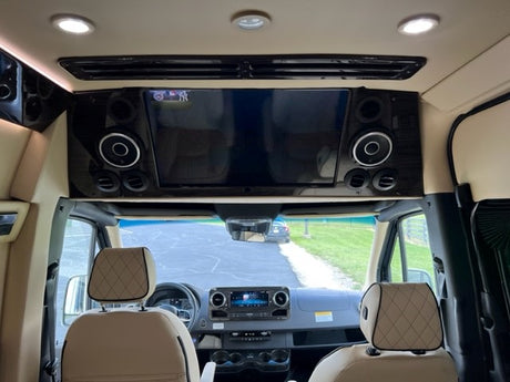 Luxury RV rental interior with TV, speakers, and plush front cabin. Ideal for comfortable road trips.