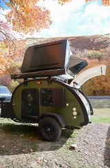 Green Bean teardrop trailer rv rental with rooftop tent, rear hatch open, parked in vibrant fall foliage. Ready for camping!