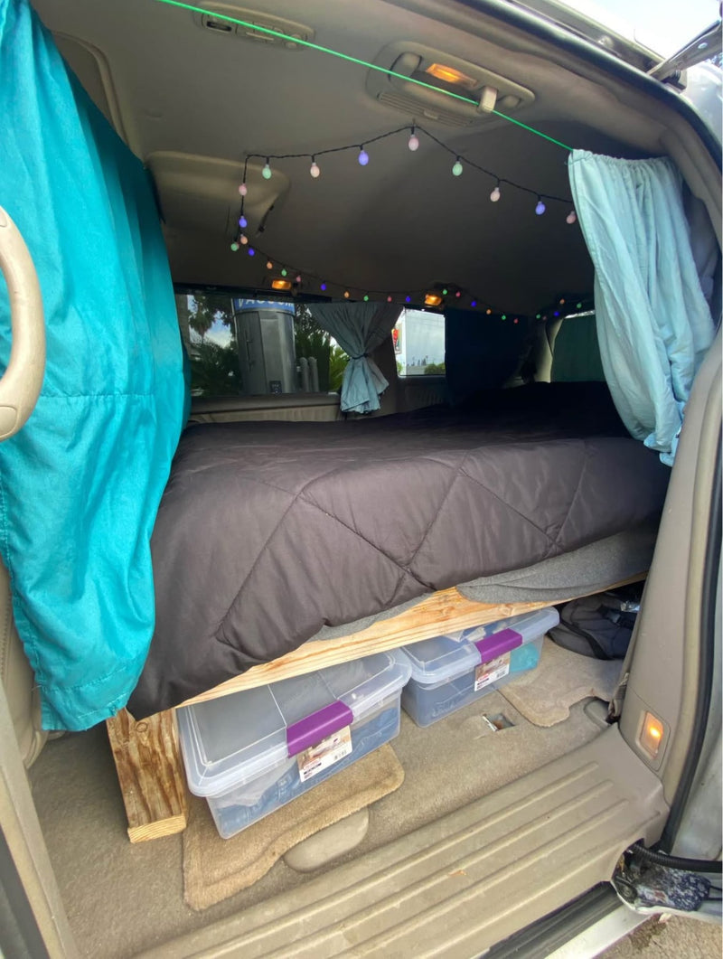  and camp essentials.|Converted van's interior featuring a raised bed with storage — photo 5