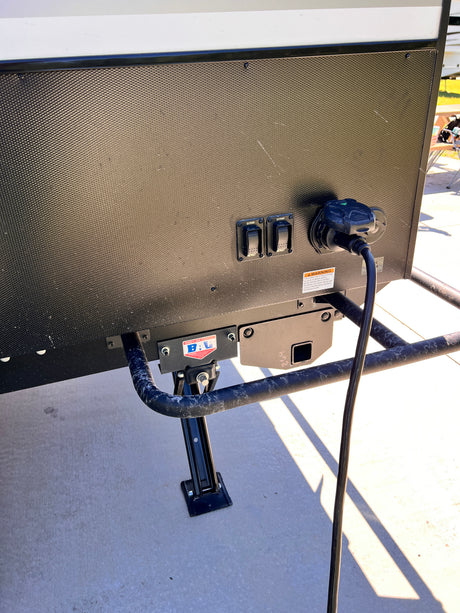 RV rental: Shore power connected, and 'EXTEND/RETRACT' controls for the automatic leveling/stabilizing jacks visible on its exterior panel.