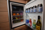 RV rental mini-fridge stocked with Maui beer, kombucha, water, fresh fruits (oranges, dragon fruit), and veggies.