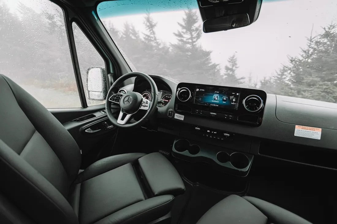 Modern Mercedes-Benz van interior, ideal for an RV rental. Spacious driver's cabin with dashboard, screen, and comfortable seats.