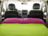 RV rental: A cozy minivan interior transformed into a bed with a vibrant green mattress and purple pillows, ideal for camping travel.