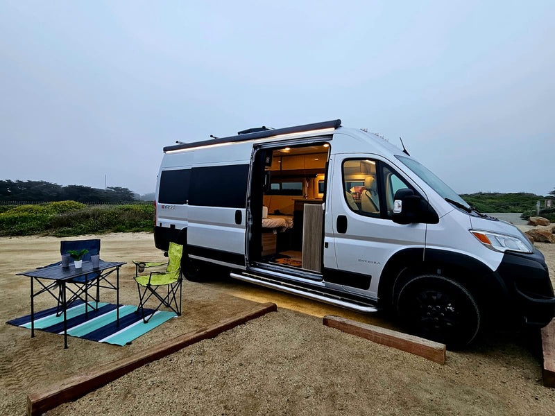  overlooking Morro Rock and the ocean.|A white RV rental van and SUV parked on a misty — photo 3