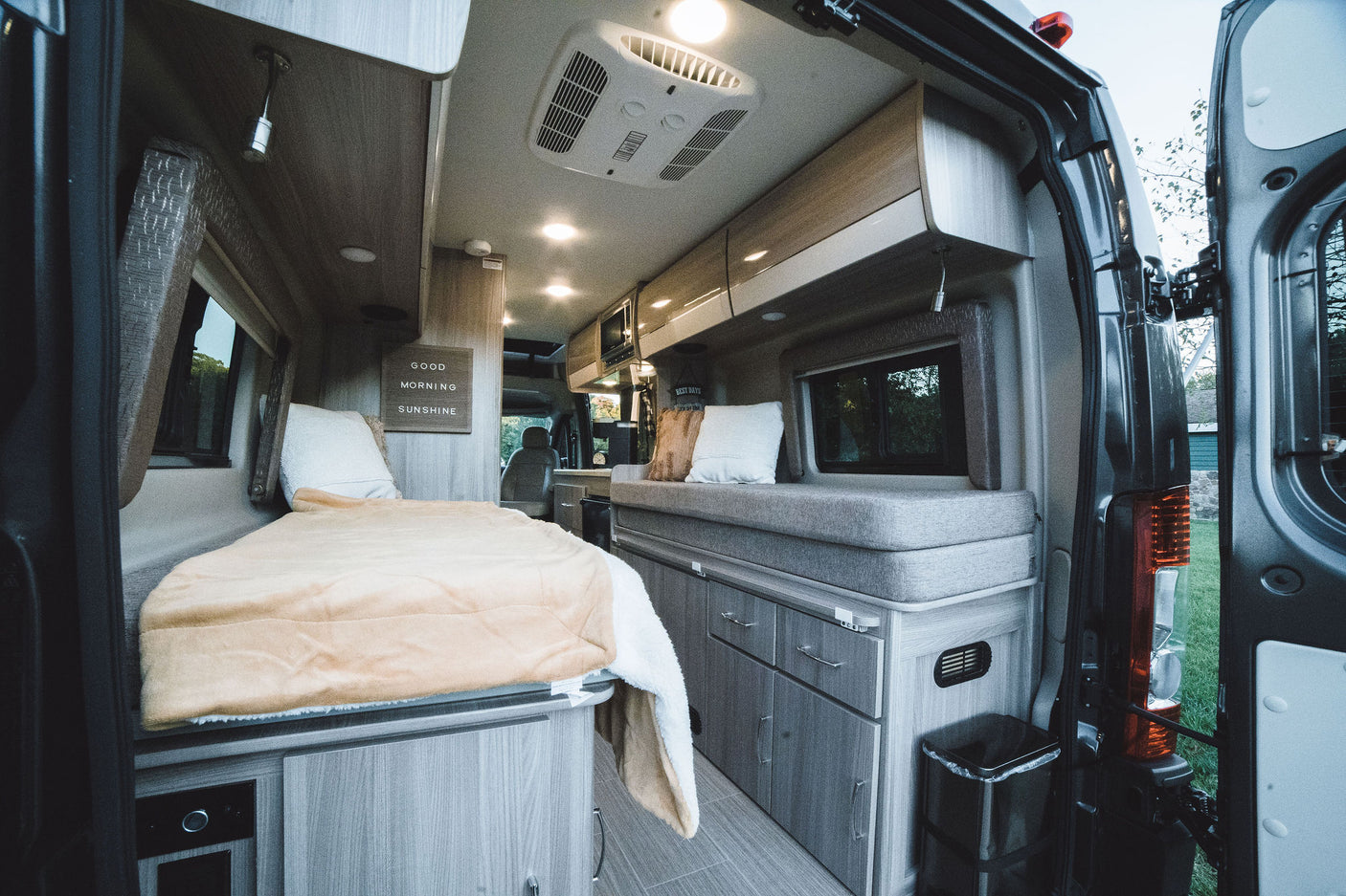 Step into this cozy RV rental's interior! Features a comfortable bed, bench seating, and ample storage.