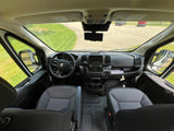 Spacious RV rental cabin: driver's view of the dashboard, steering wheel, seats, and clear road ahead.