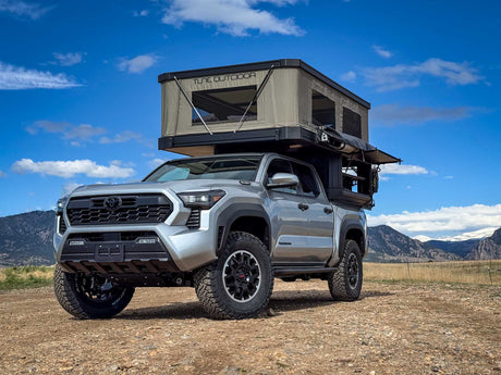 Silver Toyota Tacoma truck with a large Tune Outdoor rooftop tent