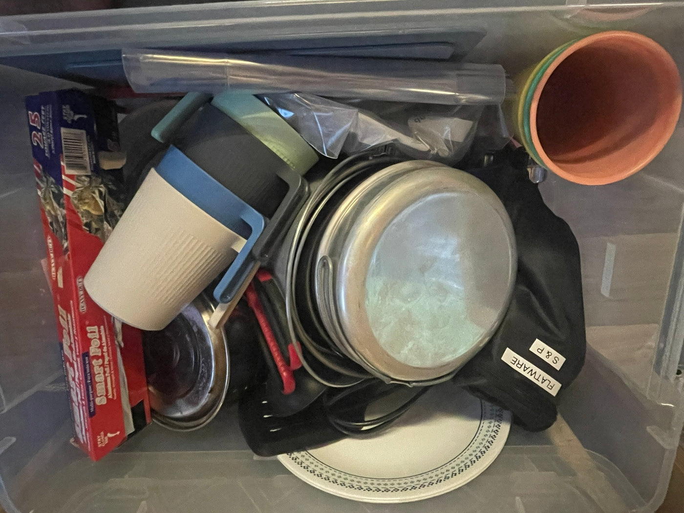RV rental kitchen kit: foil, mugs, pots, flatware, & plates packed for convenience in a clear bin. — photo 17
