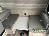 Cozy RV rental dinette featuring gray bench seating, a white tabletop, and light wood-paneled walls.