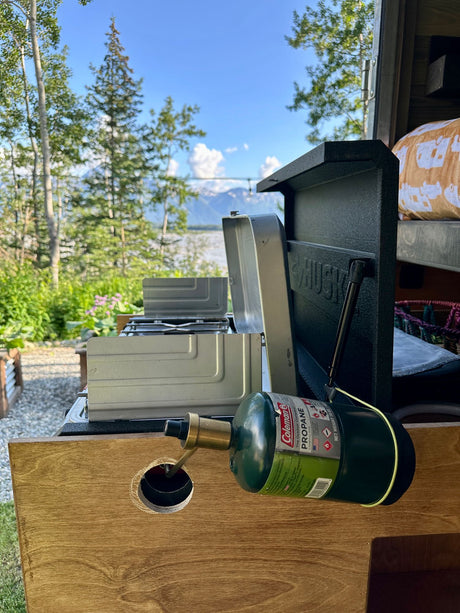 RV rental outdoor kitchen: propane stove ready for cooking with a scenic lake and mountain view.