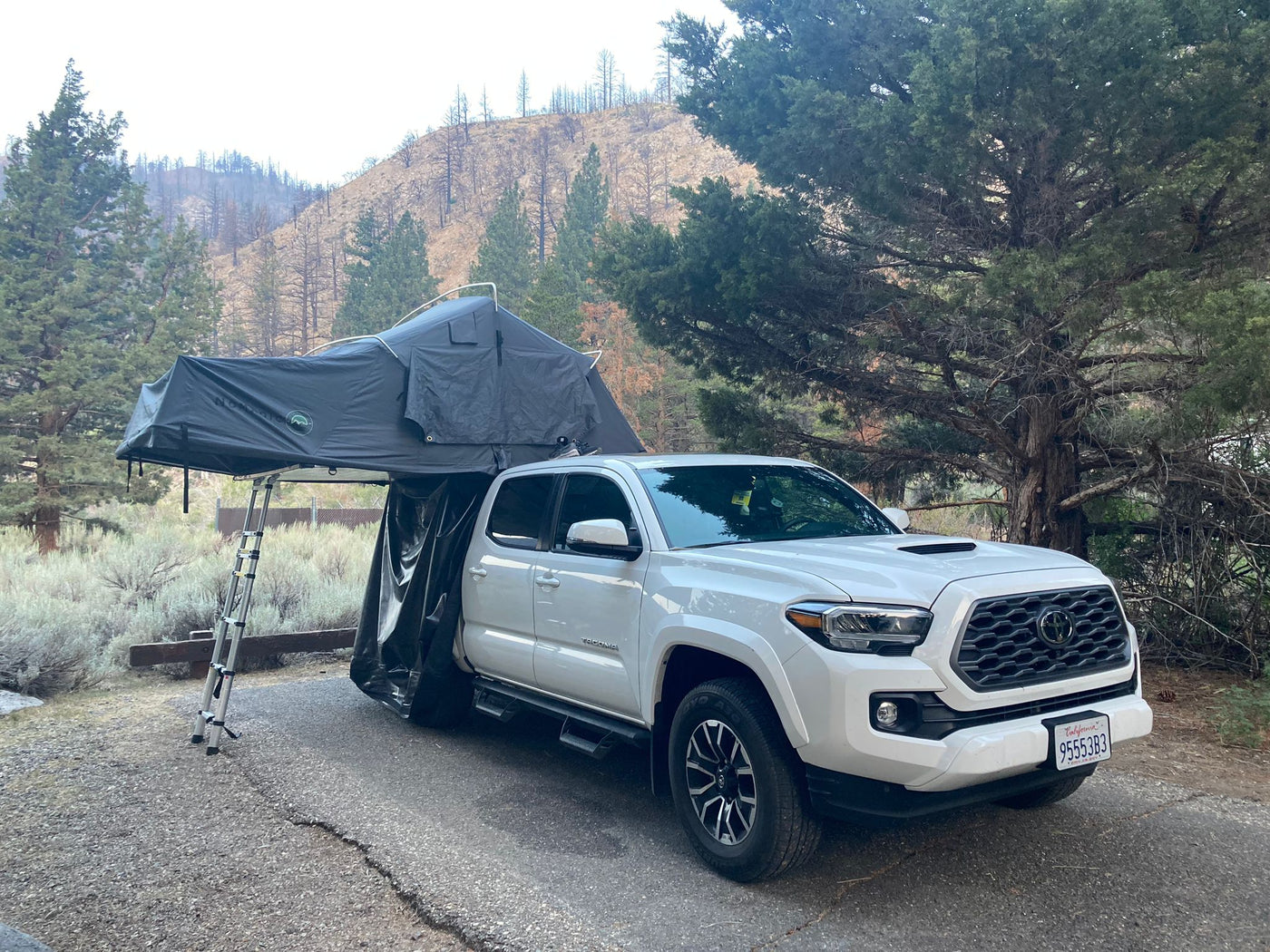  ready for outdoor adventure. Great for exploring remote areas where an RV rental may not reach.|White Tacoma truck with rooftop tent (RV rental option) parked in mountains. A large — photo 2