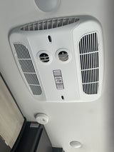 RV rental ceiling featuring a white Coleman Mach air conditioner with adjustable vents and a smoke detector.