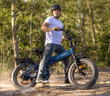 Man in helmet on a teal Jasion fat-tire e-bike on a dusty path. Explore new trails with your RV rental.