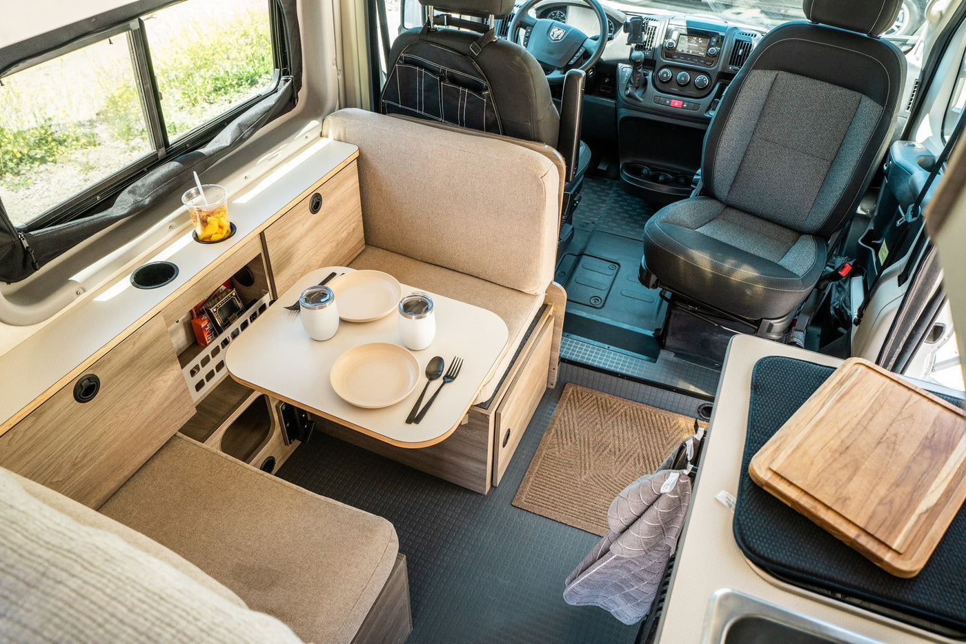 This RV rental interior shows a compact, modern space with a cozy dinette, organized storage, and front cabin view. — photo 3