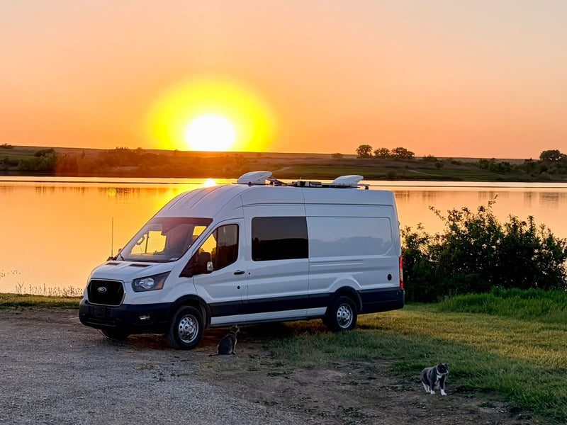 White rv rental van by a serene lake at sunset — photo 1