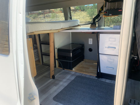 Van conversion for rv rental: Features a comfy bed, portable fridge, catalytic heater, and storage, ready for adventure.