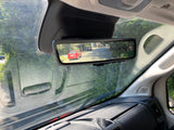 Inside an RV rental: Digital rearview mirror shows a street scene, enhancing driver visibility.