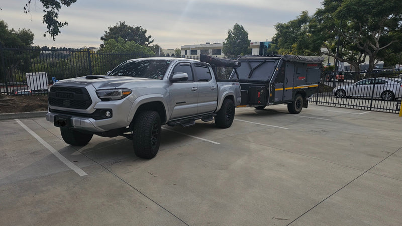 Silver Toyota Tacoma towing a rugged Conqueror off-road camper trailer, an ideal setup for an RV rental adventure. — photo 18