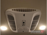 Overhead view inside an RV rental, showcasing the central air conditioning unit with vents and two bright ceiling lights for comfort.