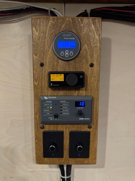RV rental power system controls: Victron battery monitor (13.5V), Eberspächer heater, inverter/charger, & light dimmers.