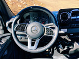 Interior of a Mercedes-Benz RV rental, showing the modern dashboard, steering wheel, and climate controls on a sunny day.