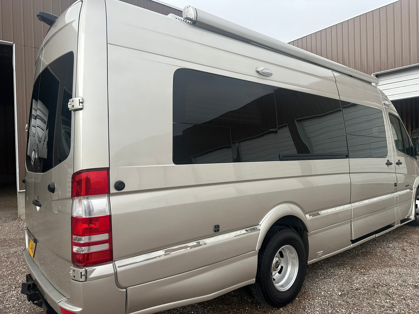  lined up outdoors near a building with a red roof.|This Roadtrek Mercedes-Benz Sprinter camper van — photo 2
