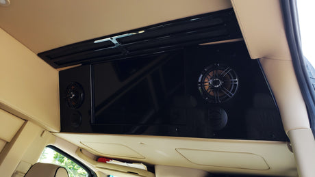Overhead entertainment system in an RV rental, featuring a large screen TV, integrated speakers, and climate vents.