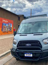 Wylder, a gray Ford Transit RV rental, parked by a "Greetings from Moab" mural. Ready for adventure in Colorado!