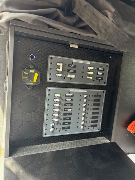 RV rental's main electrical panel displays comprehensive AC/DC power distribution controls, battery switch, and circuit breakers.