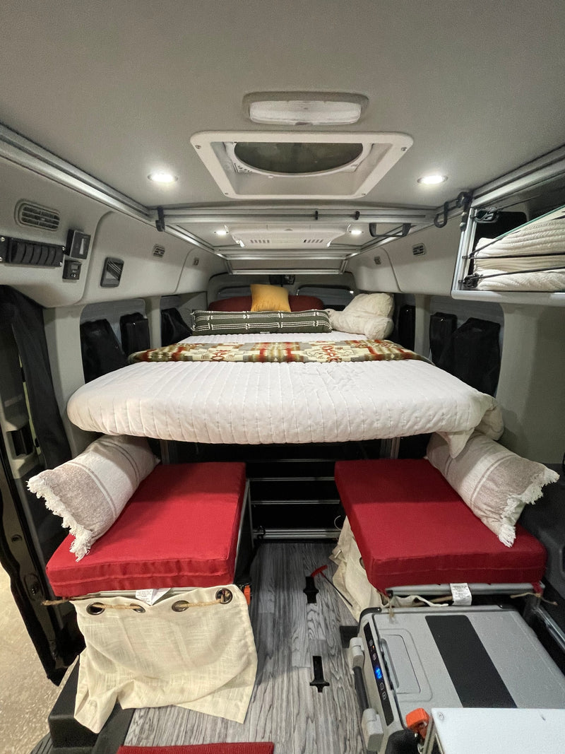 Inside an RV rental: a clever, elevated bed over red bench seating, perfect for adventurous road trips. — photo 13