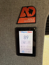 Inside an RV rental: An Agile Offroad patch above an Aqua-Hot control panel displaying 89° temp, set to 70°.