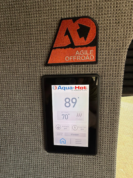 Inside an RV rental: An Agile Offroad patch above an Aqua-Hot control panel displaying 89° temp, set to 70°.
