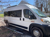 Spacious white Ram ProMaster van with large side windows and roof rack, perfect as an RV rental.