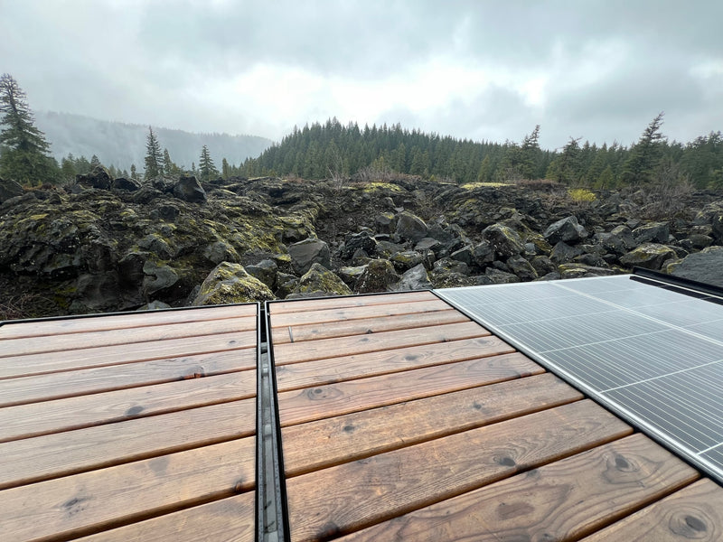 RV rental deck with solar, facing rugged lava rocks & a misty forest landscape on a cloudy day. — photo 2