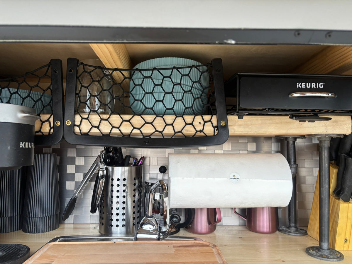  and wall-mounted folding chairs and a white table.|Cozy RV rental interior with a comfortable bed — photo 6