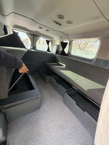 RV rental interior featuring flexible seating/bed, pull-out storage drawers, and hidden under-cushion compartments.