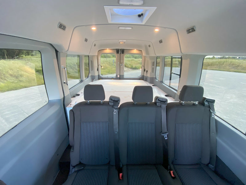 RV rental van interior features three passenger seats, a rear bed area, and large windows. Bright and spacious setup. — photo 5