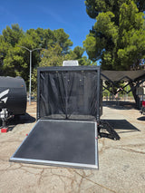  and versatile bed setup in this toy hauler.|Modern Hopper RV rental: A white and black camper with an awning