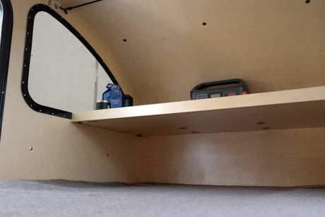 RV rental: light wood camper interior with shelves, a Jackery power station, and coffee items.