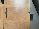 RV rental amenities: Close-up on light wood cabinets, black handle/latch, and a power outlet with USB & ON/OFF switch.