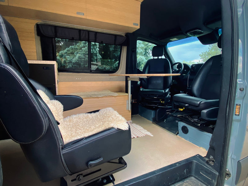  and a view outside.|RV rental interior: a compact camper van with wooden walls — photo 4