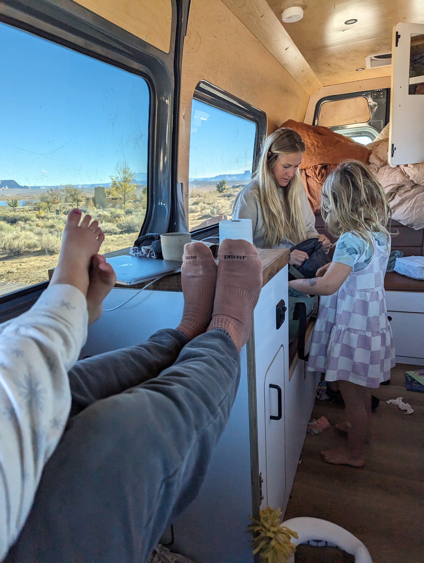 Relaxing in an RV rental: family enjoys scenic views with feet up. A woman and child organize inside their mobile home. — photo 11