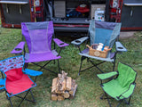 Relaxing campsite setup: An RV rental with family camping chairs and firewood for s'mores, ready for a cozy evening.