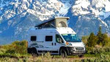 Majestic snow-capped mountains frame this white camper van RV rental, perfect for your next outdoor adventure.