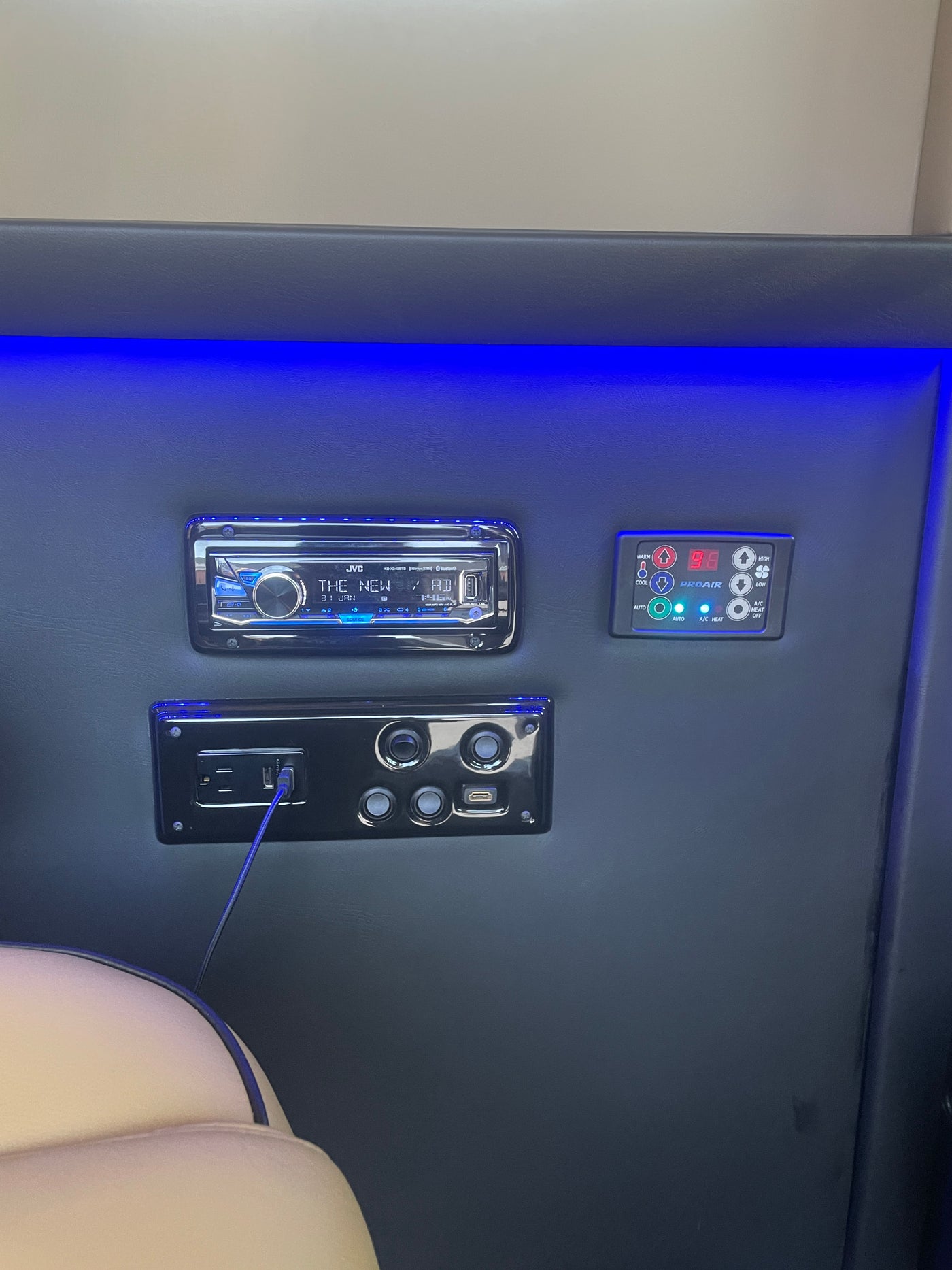 RV rental interior showing a JVC stereo, PROAIR climate control (displaying 98 degrees), and power/USB outlets with blue ambient lighting. — photo 6