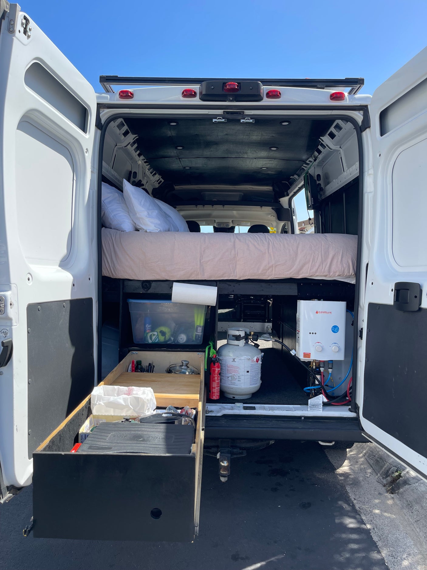 This RV rental offers a full camper van conversion with a cozy bed, ample storage, and a portable water heater for adventure.