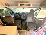 RV rental camper van interior. Front cabin with Ford dashboard, steering wheel, and driver/passenger seats.