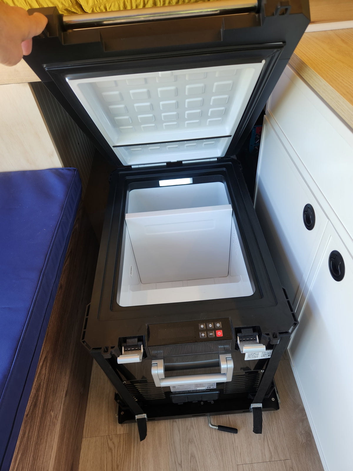 RV rental: Open portable fridge with illuminated interior, control panel, and storage basket. Hand holds the lid. — photo 9