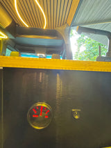 Inside a custom **rv rental**: wooden ceiling with LED lights & a water level gauge on a control panel with a power switch.