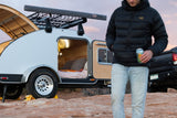 Book an RV rental! This sleek teardrop camper, with cozy interior and roof rack, is ready for adventure in red rock country.